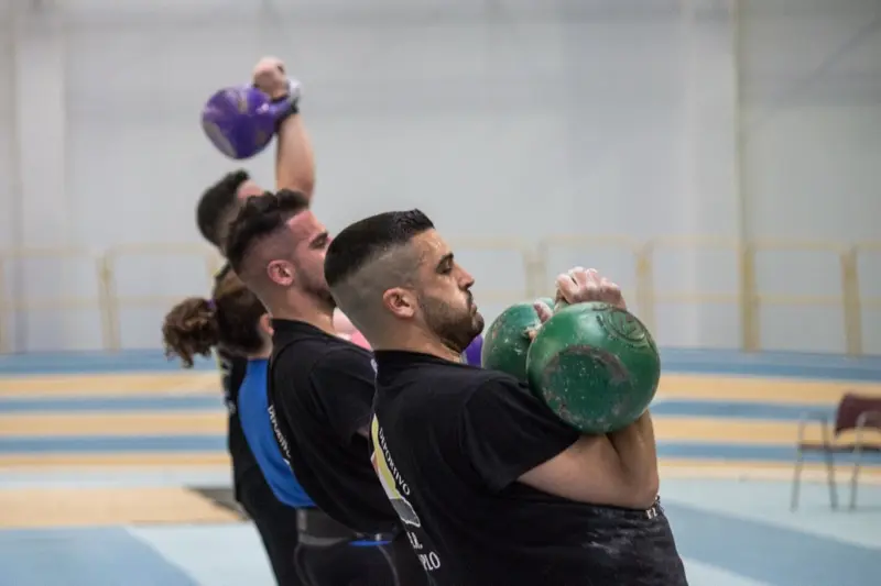 Athletes performing kettlebell jerks in competition at IKMF World Championship
